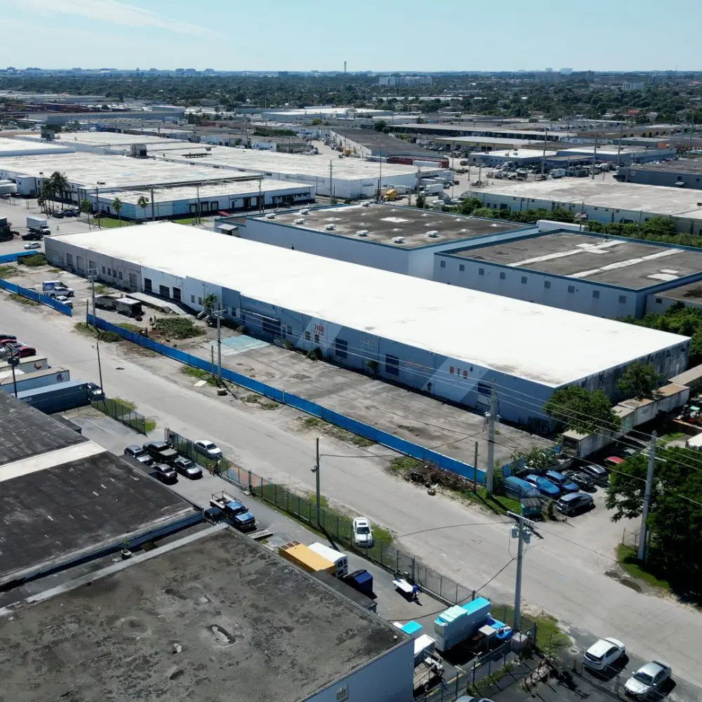 A large warehouse with many cars parked in it.